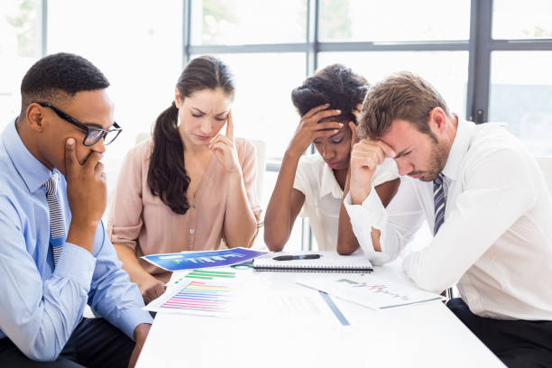 istock Depressed businesspeople sitting at table during a meeting 668272148