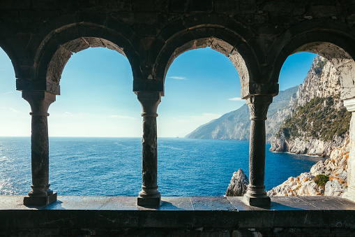 Terrace with arches overlooking scenic sea view and mountains in Italy. Travel background