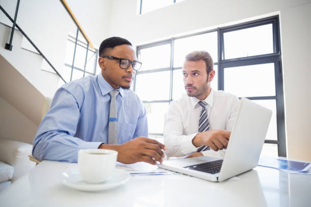 istock Businessmen looking at laptop and interacting in office 668278450