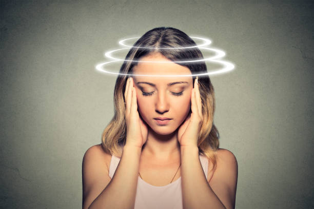 Woman with vertigo. Young female patient suffering from dizziness. stock photo