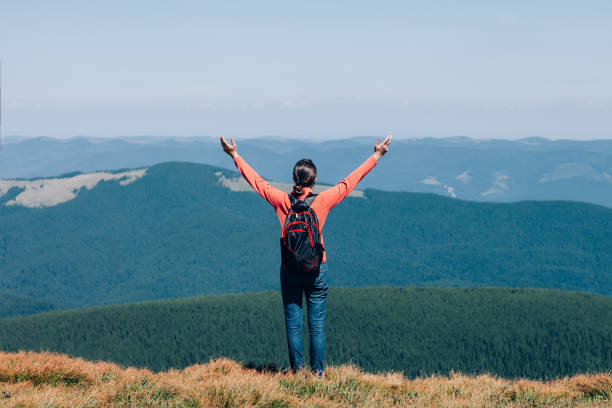 istock Freedom young girl with hands up in mountains 668290068