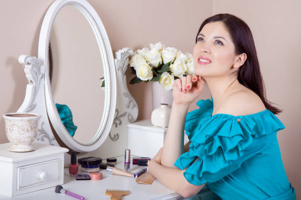 istock Young beautiful woman with dress apply makeup. 668296056