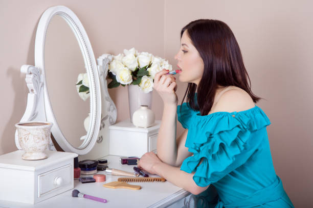 istock Young beautiful woman with dress apply makeup. 668296078