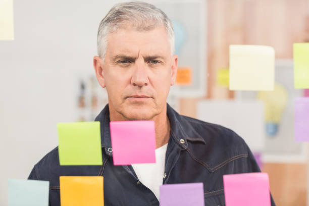 istock Casual businessman looking at a post it wall 668303506