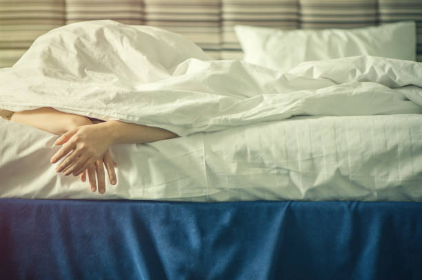istock Female hands under blanket at sunset. Sleeping girl 668325274