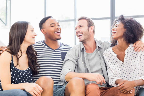 istock Friends sitting on sofa and laughing 668326344