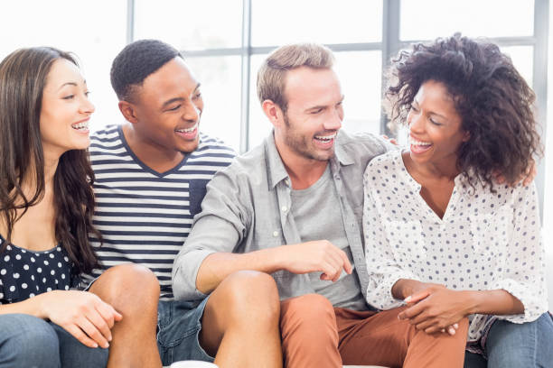 istock Friends sitting on sofa and laughing 668326440