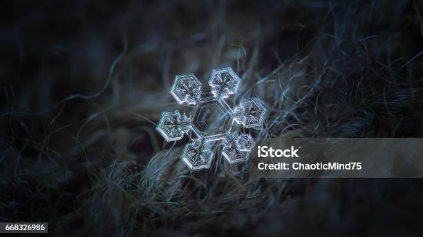 Snowflake Glowing On Dark Cyan Woolen Background Stock Photo - Download Image Now - Magnification, Snowflake Shape, Abstract