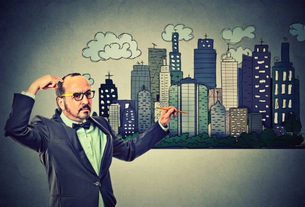 istock Man drawing city skyline on gray wall background 668329378