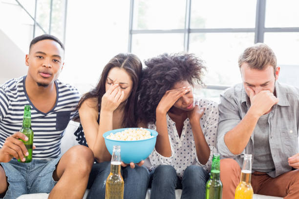 istock Friends sitting on sofa with a bowl of popcorn 668329708