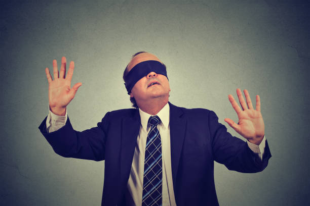 istock middle aged business man in suit blindfolded stretching his arms out 668329922