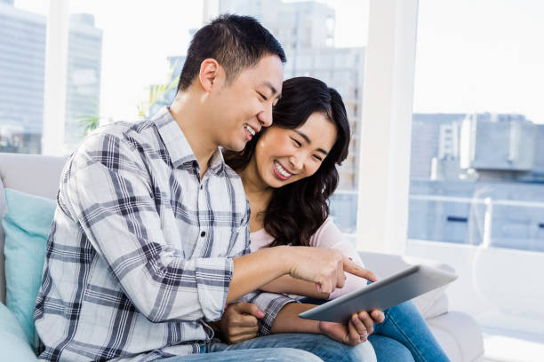 istock Young cheerful couple looking at digital tablet 668340014