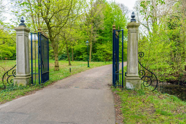 istock Black iron fence with golden decoration is opened hospitable 668359724