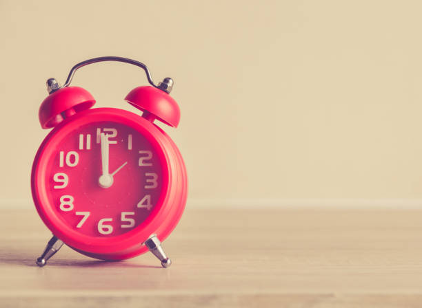 istock Retro alarm clock on a table. Photo in retro color image style 668360804