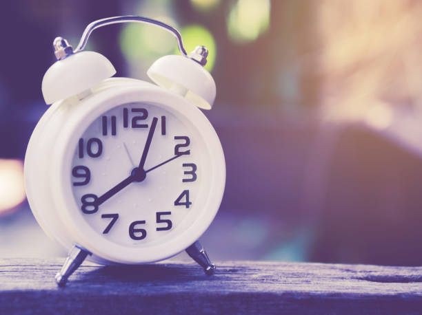 istock Retro alarm clock on a table. Photo in retro color image style 668360904