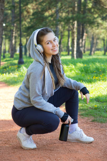 istock Young pretty girl doing exercise and running in the park 668368390