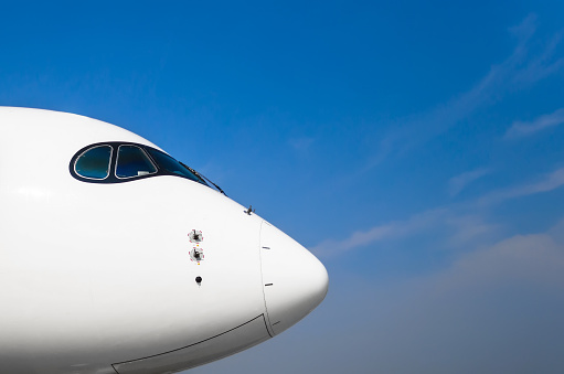 Nose and cockpit of pilots aircraft on a background of blue clear sky.