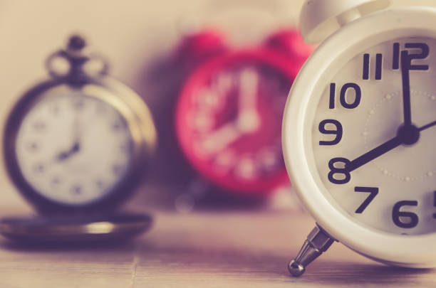 istock Retro alarm clock on a table. Photo in retro color image style 668371706