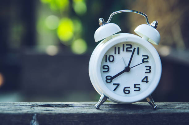 istock Retro alarm clock on a table. Photo in retro color image style 668374938