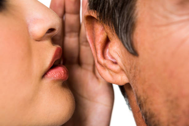 女性が男の耳にささやく - listening human ear communication human hand ストックフォトと画像
