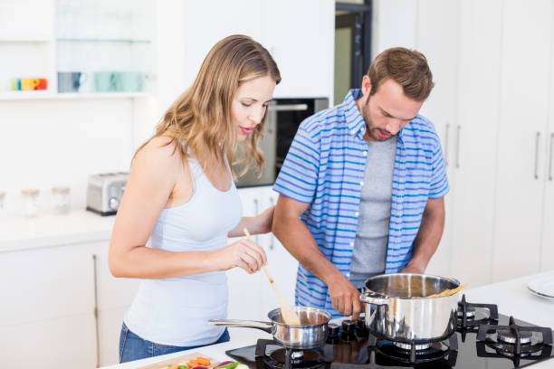istock Young couple preparing a meal in kitchen 668385902