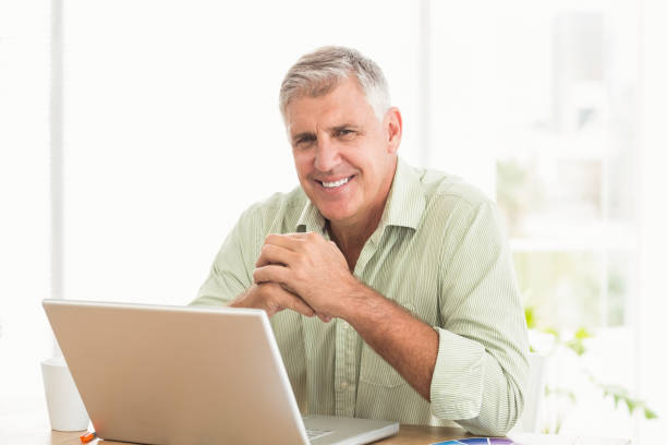 istock Smiling businessman working on a laptop 668392226