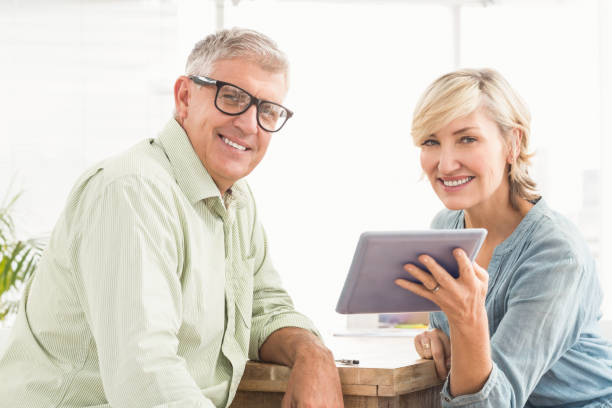 istock Smiling business team working on a tablet 668395252