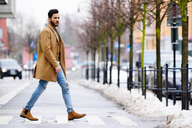 istock Young man in beard crossing winter street 668395352