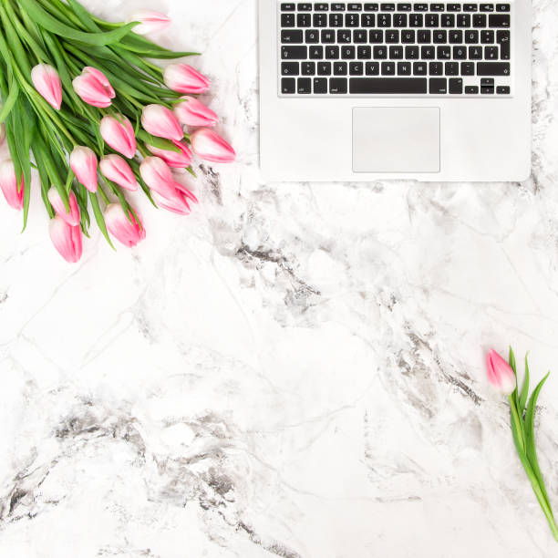 istock Office desk flat lay flowers Laptop tulips 668403400