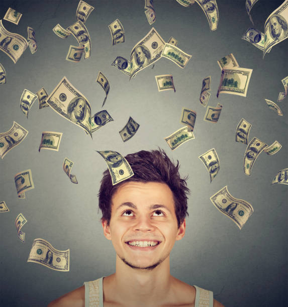 istock Happy man under money rain falling down dollar bills 668406226