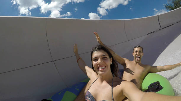 istock Couple having fun and sliding down in a water slide 668413020