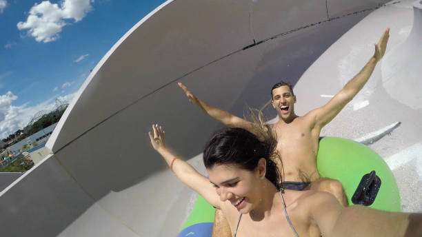 istock Couple having fun and sliding down in a water slide 668413048