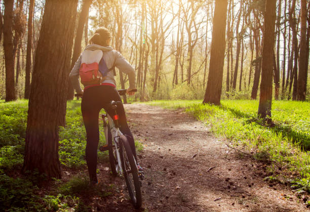 istock Young woman riding a bicycle in the forest 668416240