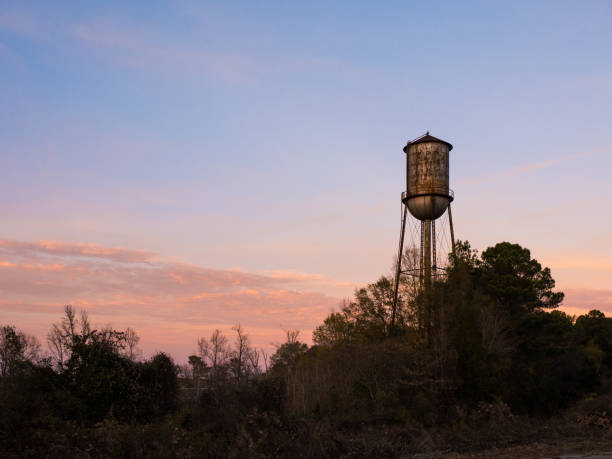 istock Old Small Town Water Tower Against Sunset Sky 668416776