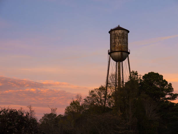 istock Old Small Town Water Tower Against Sunset Sky 668416780