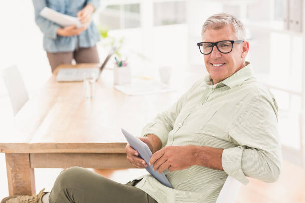 istock Smiling businessman holding a tablet 668419580