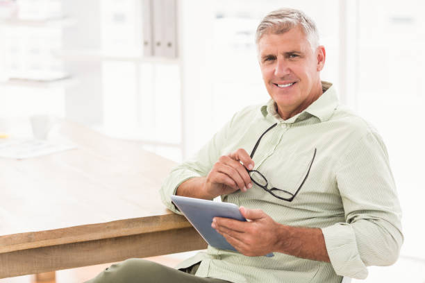 istock Smiling businessman holding a tablet 668419684