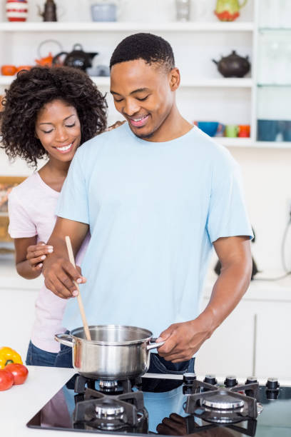 istock Young couple preparing a meal in kitchen 668420348