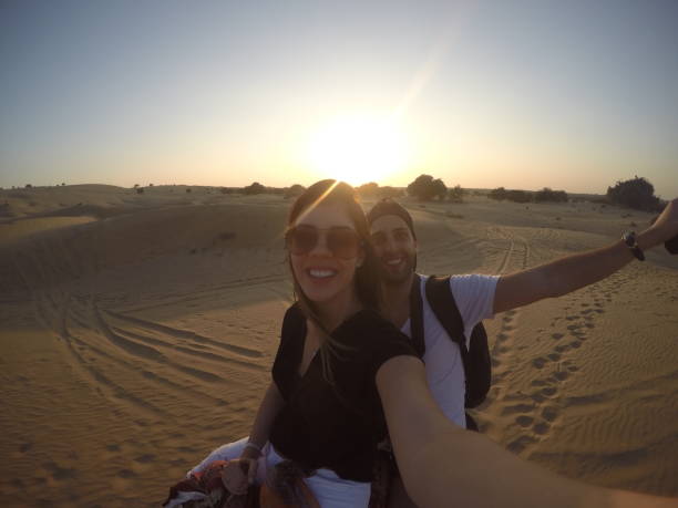 coppia che si fa un selfie in un cammello a cavallo nel deserto - india travel journey camel foto e immagini stock