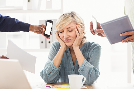 Overwrought businesswoman covering her ears at the office