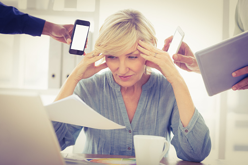 Overwrought businesswoman with hands on head at the office