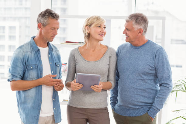 istock Smiling business colleagues discussing over a tablet 668426556