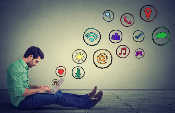 istock Side profile young man working on laptop using social media application sitting on a floor 668426576