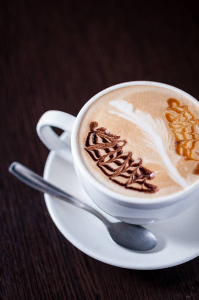 istock Cup of coffee with a white leaf drawing 668426702