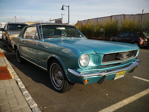 Harrison New Jersey - April 5 2017. Late 1960s Turquoise Ford Mustang convertible parking on the street