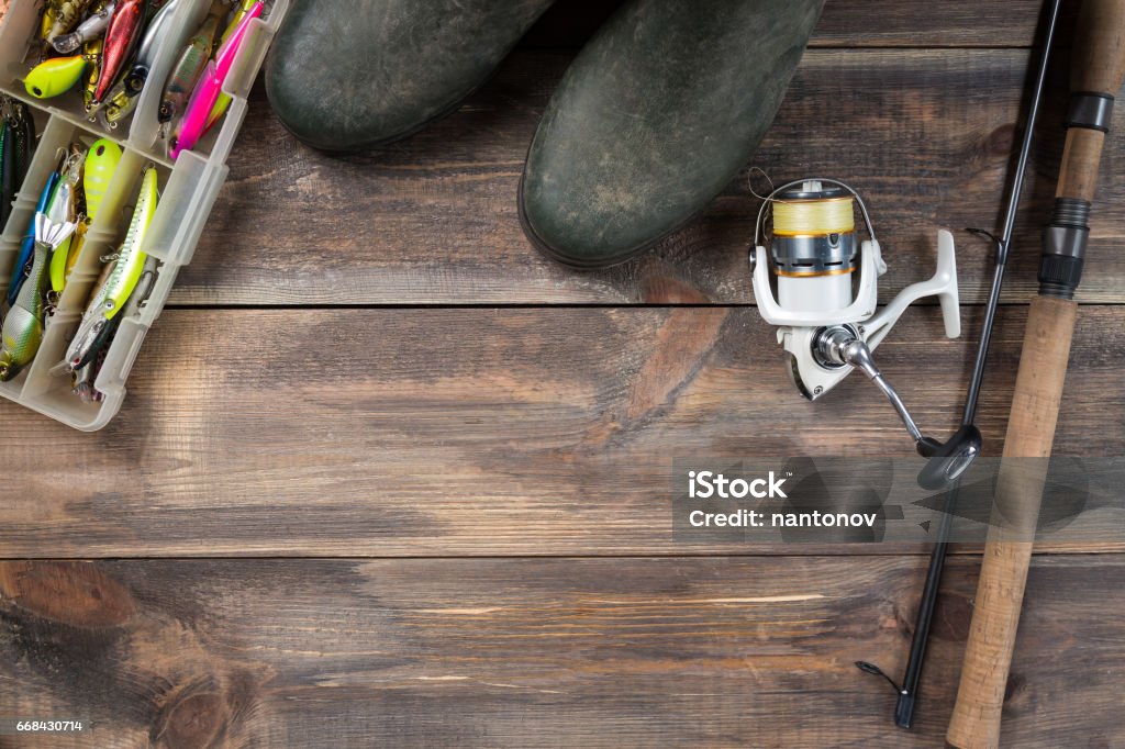 Fishing Rods And Reel With Boots And Fishing Tackles In A Box On Wooden  Background With Free Space Stock Photo - Download Image Now - iStock