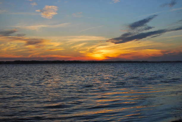 istock Colorful sunset over water with beautiful clouds 668430960
