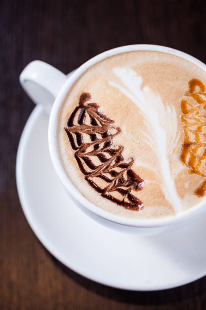 istock Cup of coffee with a white leaf drawing 668433890