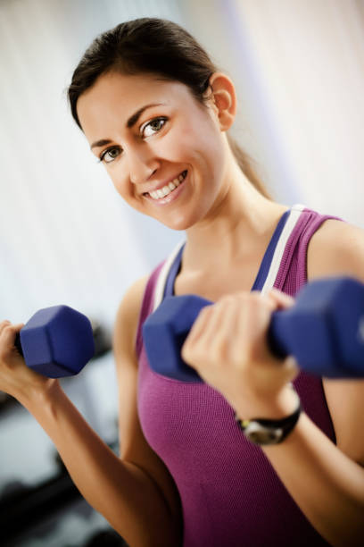 istock Young Woman Doing Arm Curls With Dumbbells 668433908