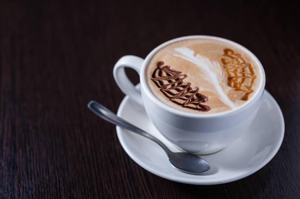 istock Cup of coffee with a white leaf drawing 668434262